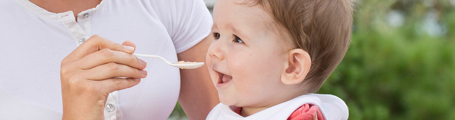 A person is feeding a baby with a spoon.