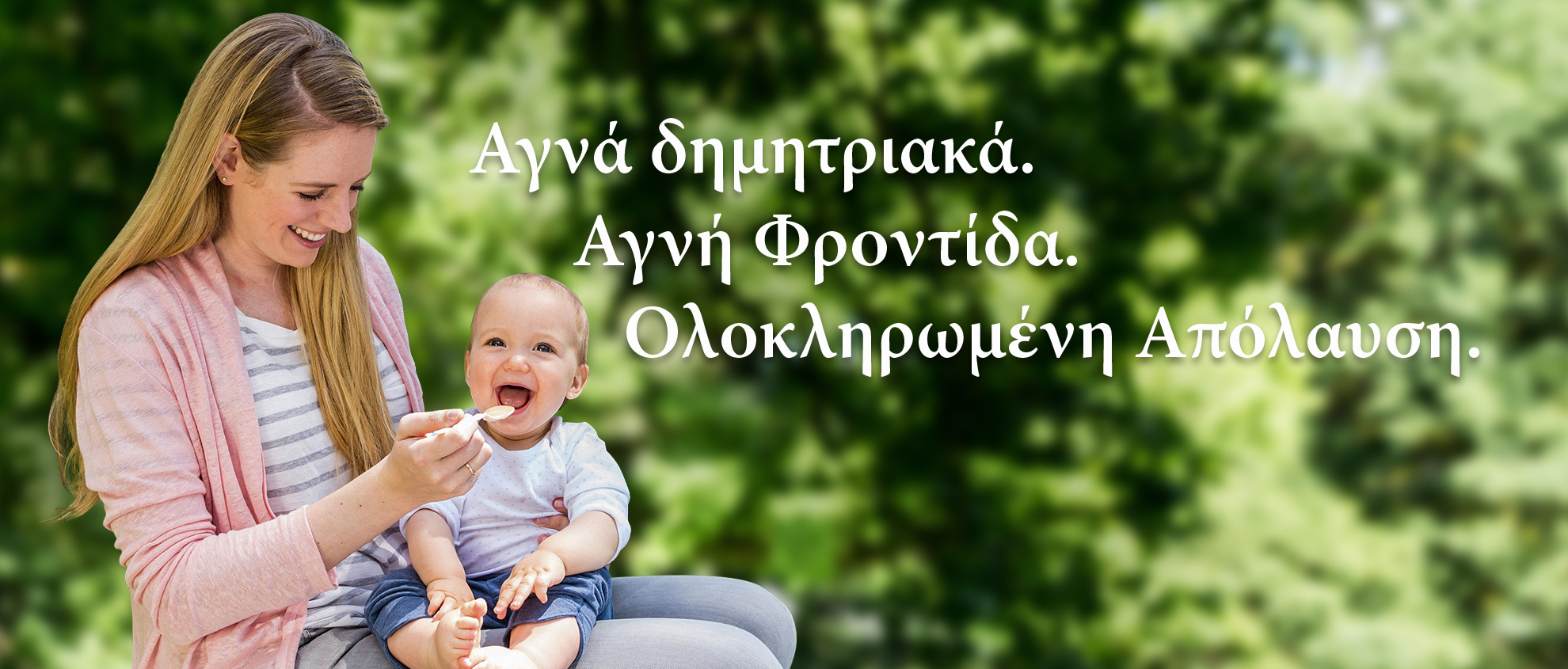 Μια γυναίκα ταΐζει ένα μωρό σε ένα καταπράσινο υπαίθριο περιβάλλον.